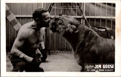 photographie en noir et blanc d'un homme embrassant un chien dans une cage