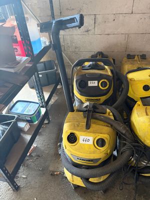 several yellow vacuum cleaners are lined up in a room