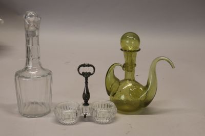trois objets en verre différents posés sur une table avec une bouteille
