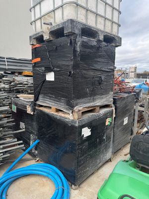 une pile de boîtes noires et une tondeuse à gazon verte