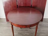 an oval mahogany dining table with four chairs on casteors