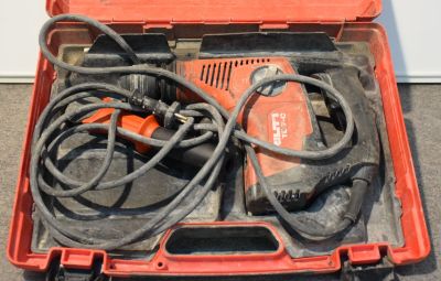 une boîte à outils rouge contenant une perceuse et d'autres outils