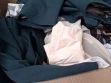 a cardboard box filled with clothes and clothing on the floor