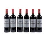 four bottles of wine are lined up on a white surface