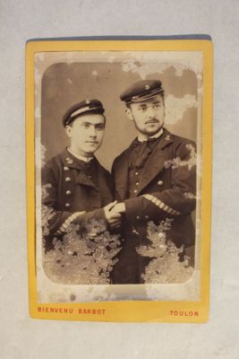 une vieille photo montrant deux hommes en uniforme debout l'un à côté de l'autre