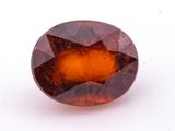 a picture of an oval shaped brown and orange gemstone