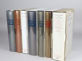 several books are stacked on top of each other in a row