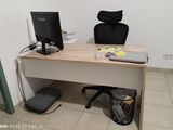 un bureau avec un ordinateur et une chaise dans un coin