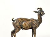 bronze statue of a goat on a base on a white background