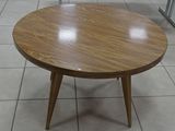 a small table with a wooden top on a tiled floor