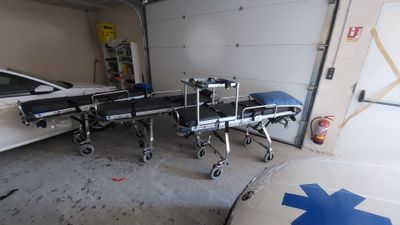 une voiture garée dans un garage, avec une civière devant