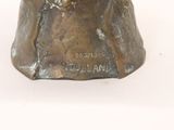 a bronze statue of a woman with a hat on her head