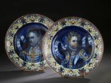 two decorative plates with a painting of a man and a woman on them