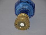 a blue glass bottle with a gold lid on a table