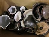 a cardboard box filled with many different types of cups and saucers