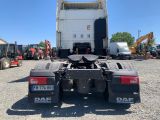 the back end of a white dump truck parked in a lot