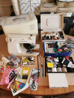 une table sur laquelle se trouvent une machine à coudre et de nombreux autres objets