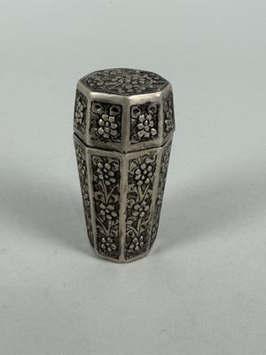 an antique silver vase with a floral design on it