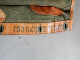 a green bag with numbers on it sitting on the floor