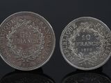 a close up of two silver coins on a black surface