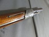 an old rifle with a wooden handle on a gray surface