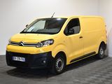 La camionnette jaune est garée dans une pièce blanche au sol à carreaux.