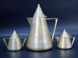 three silver coffee pots and a teapot on a blue background