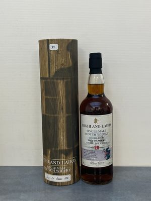une bouteille de whisky posée à côté d'une boîte en bois sur une table