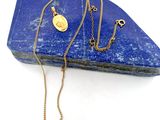 collier plaqué or orné d'un lapis-lazuli bleu sur fond blanc