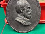 une image représentant un médaillon en bronze à l'effigie d'un homme