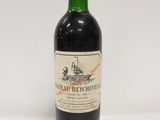 une bouteille de vin rouge posée sur une table blanche