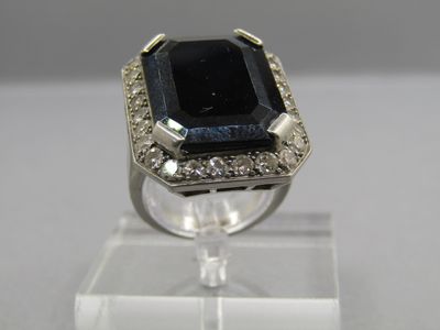 an image of a ring with a black stone surrounded by white diamonds