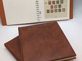 an open notebook with a brown cover and a brown book