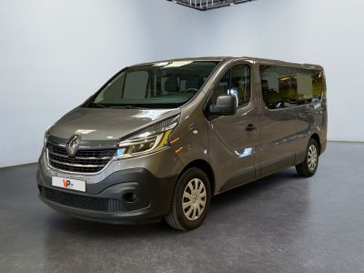 une camionnette grise garée dans une grande pièce, avec un ventilateur de plafond en arrière-plan
