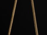a close up of a gold necklace on a black background
