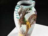 a vase with a painting on it sitting on a table