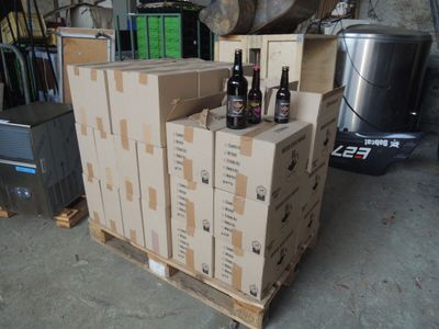 several boxes of beer are stacked on a pallet in a garage