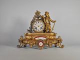 une horloge en or surmontée d'une statue
