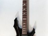 a black electric guitar hanging on a wall