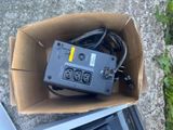 a box with a power strip inside of it on the ground
