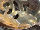a metal spoon with holes in it sitting on a marble surface