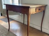 a small table with a drawer on it in a room