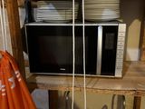 a microwave sitting on top of a shelf in a room