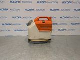 an orange and white machine sitting on top of a metal surface