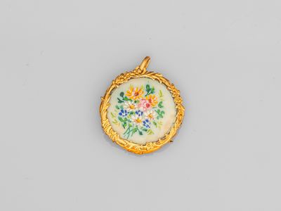 un pendentif en or et émail orné d'un motif floral