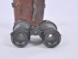 a pair of binoculars sitting on the ground next to a suitcase
