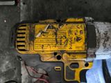 yellow and black electric drill sitting on top of a table next to other tools