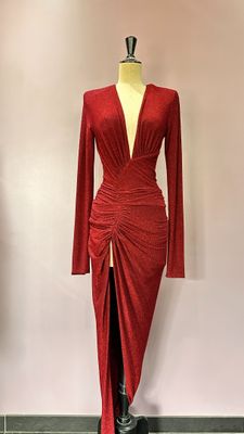 une robe rouge posée sur un mannequin devant un mur rose