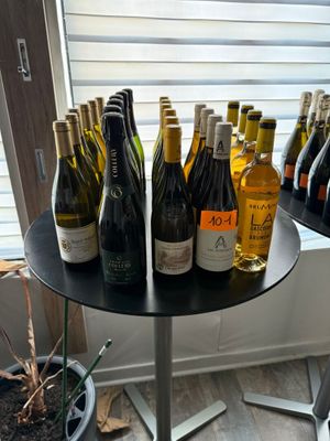 many bottles of wine sitting on a table in front of a window