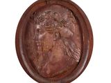une image représentant une plaque à l'effigie d'une femme coiffée d'une couronne de fleurs